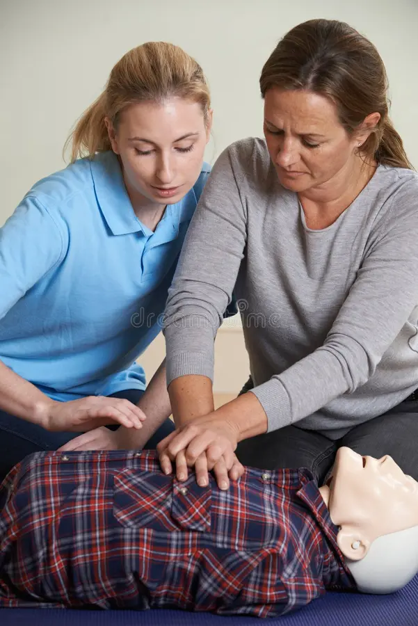 woman demonstrating cpr training dummy first aid class demonstrates 65958179